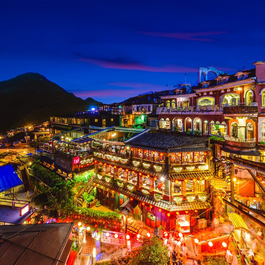 The lantern-lit teahouses of Jiufen village stacked on a hillside at dusk